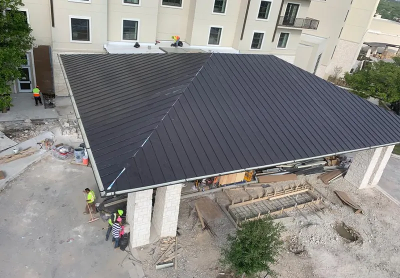 Metal roofing installation team working on a commercial building in Lacombe